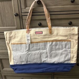 vineyard vines striped canvas tote with blue bottom and gray/white stripes.